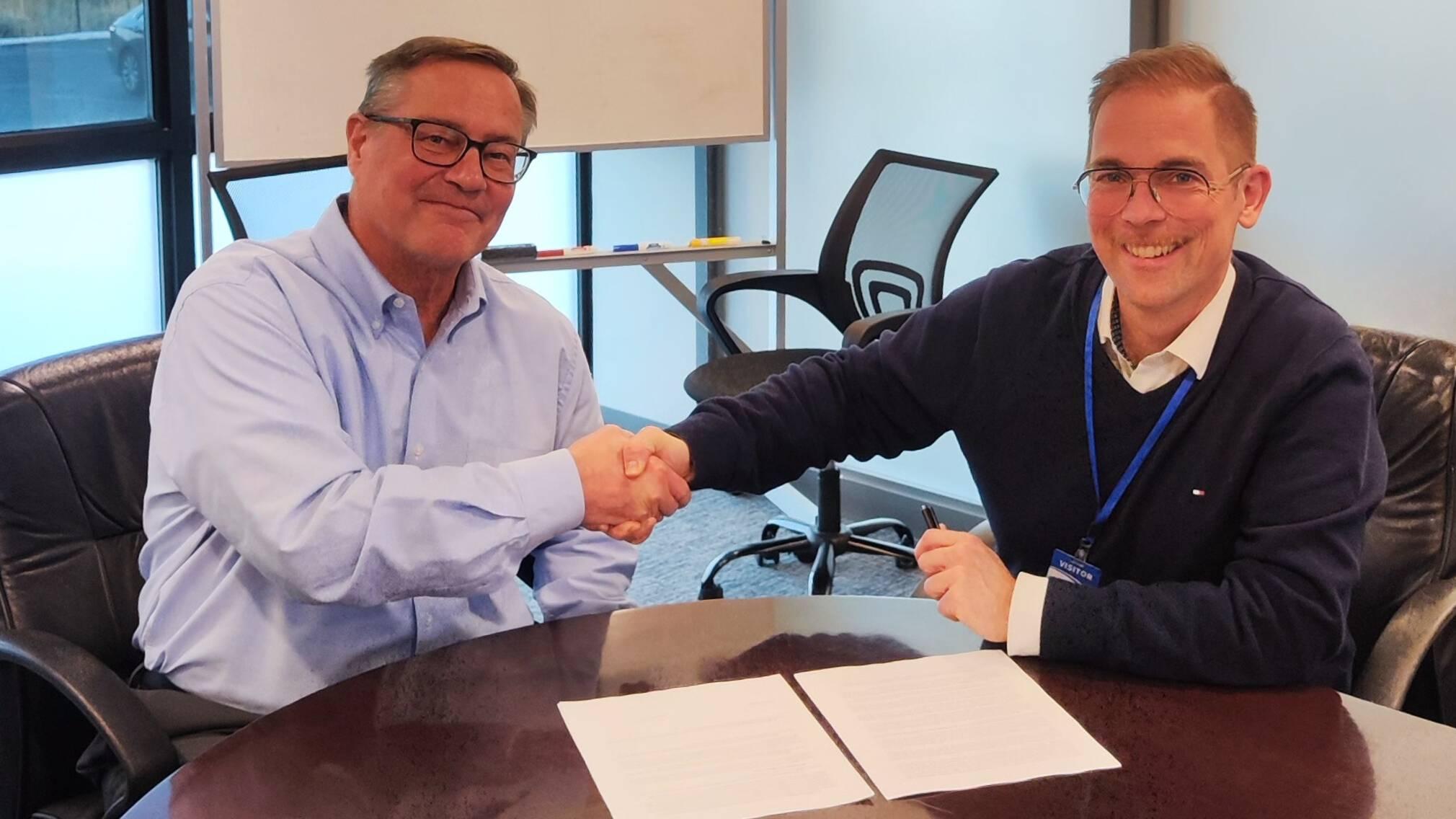 John Jutila, CEO of Tekscan, and Michael Kröger, CEO of FLEXOO, sign the cooperation agreement