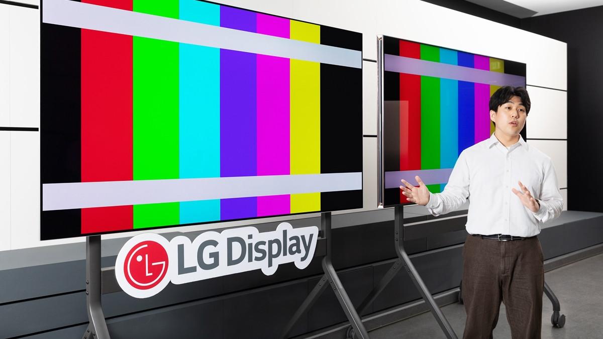 An LG employee in front of two OLED screens