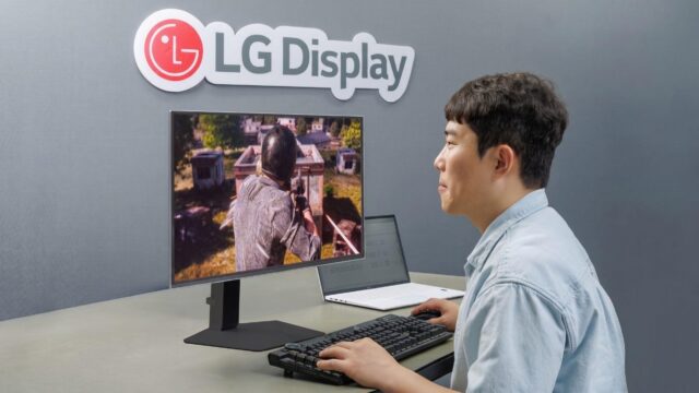 A man in front of a gaming OLED display